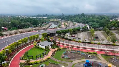 Aerial view of a Davao Coastal Road interchange with a landscaped pocket park and children's playground inside the loop