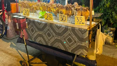 Night vendor cart of bottled drinks with handwritten 20, 25, 30 and 35 peso price tags