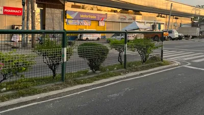 Pharmacy and motorcycle dealership tucked beneath an elevated flyover