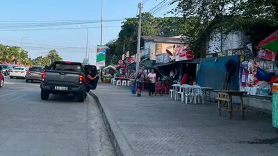 Roadside market stalls with folding tables and a pickup parked alongside