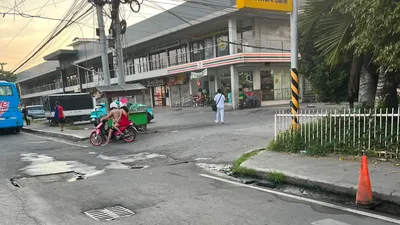 BDO Network Bank branch above a convenience store with a tricycle passing