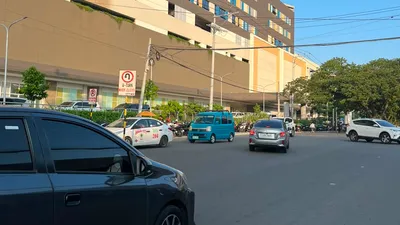 Large modern commercial block above the road with taxis passing