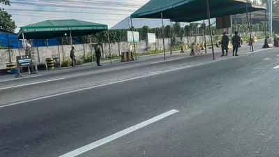 City government tents at a roadside checkpoint with palms behind