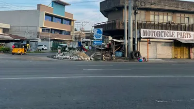 Junction overlooked by a motorcycle parts shop beneath a flyover