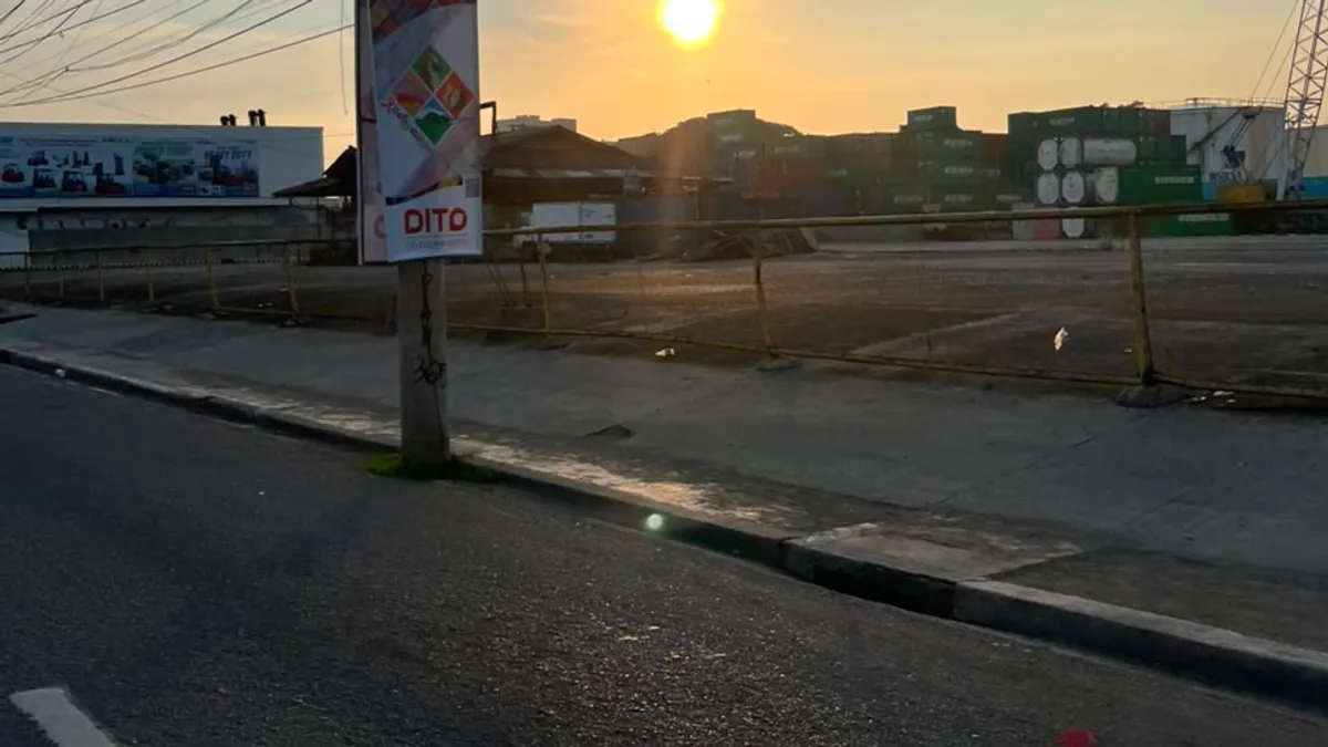 Telco promotional banner on a roadside pole at sunrise
