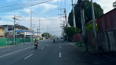 Motorcycle on a road under a dense fan of overhead utility wires
