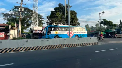 Solar street light and a cell tower over a bus passing on the highway