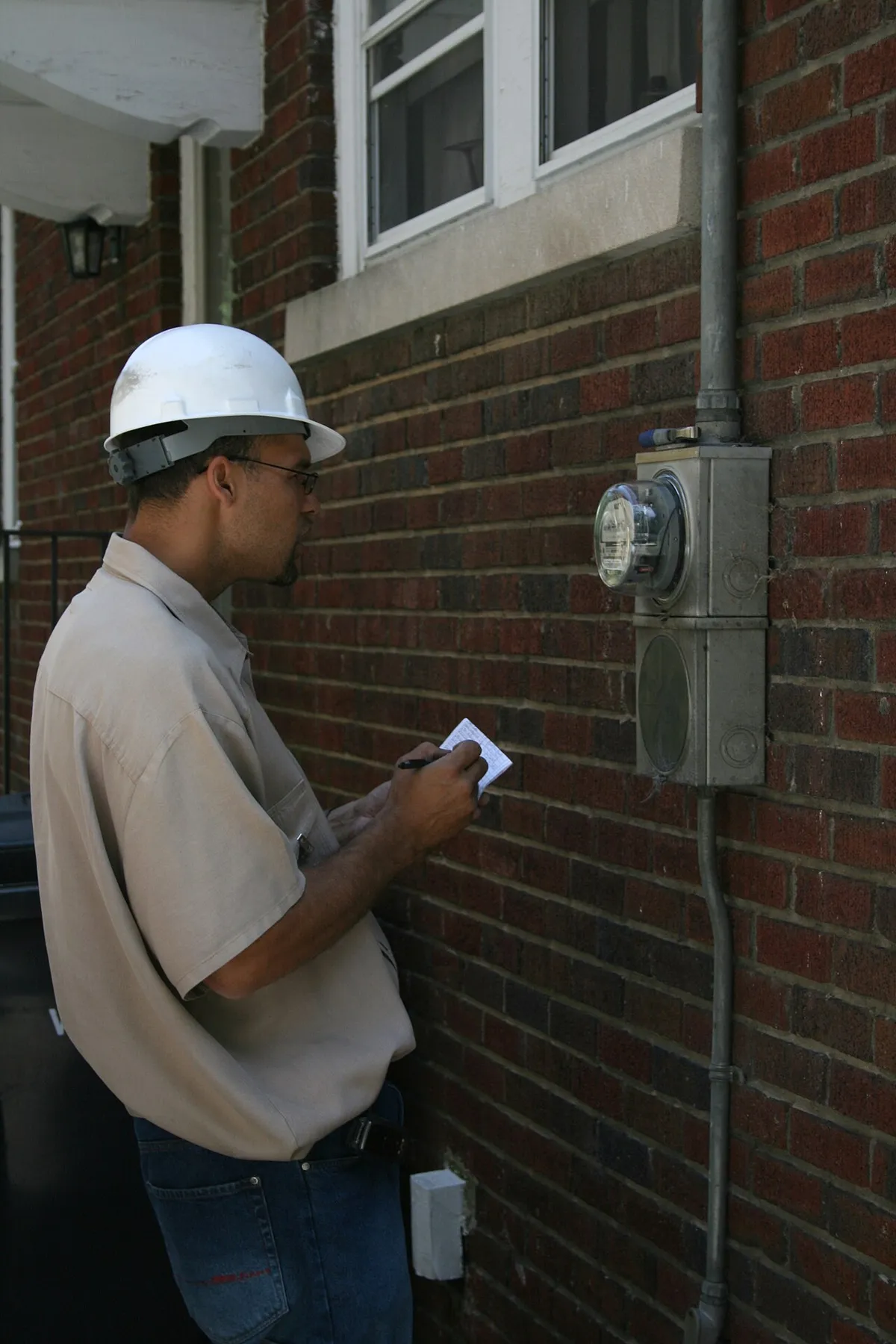 Utility worker reading an electric meter
