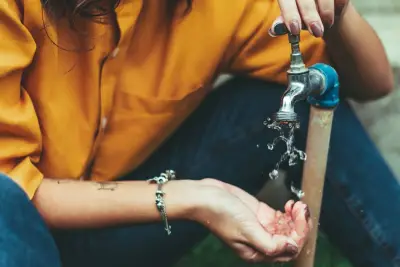 Person using a water faucet